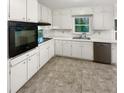 Clean kitchen featuring white cabinets, an electric range, and stainless steel dishwasher at 4726 Alpine Sw Dr, Lilburn, GA 30047