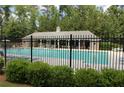 Community pool with a black fence and green trees and bushes in the background at 200 Brookwood Xing, Douglasville, GA 30134
