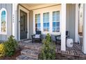 Inviting front porch with brick flooring, comfortable seating, and decorative plants at 2008 Cottonwood Ln, Woodstock, GA 30188