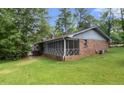 Backyard view showcasing screened porch with spacious yard and brick exterior at 3319 Colony Dr, Conyers, GA 30013