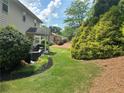 A lovely backyard with a patio and chairs is surrounded by mature landscaping at 200 Edinburgh Ln, Woodstock, GA 30188