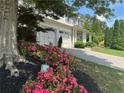 Beautiful home featuring a well-manicured front yard with lush landscaping and blooming flowers at 200 Edinburgh Ln, Woodstock, GA 30188