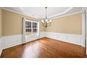 Elegant dining room with hardwood floors, crown molding, and a modern chandelier at 1105 Fountain Head Ln, Lawrenceville, GA 30043