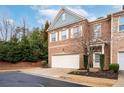 Beautiful brick townhome showcasing a well-maintained front yard and a two-car garage at 3557 Ashcroft Se Dr, Smyrna, GA 30080