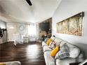 Cozy living room with a stone fireplace, ceiling fan, natural light, hardwood floors, and comfortable seating area at 3356 Hollow Ct, Lawrenceville, GA 30044