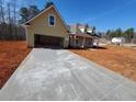 New construction exterior with yellow siding, a two-car garage, and a concrete driveway at 183 Brookwood Xing, Douglasville, GA 30134