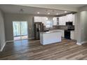 Modern kitchen with white cabinets, granite countertops, stainless steel appliances, and wood-look flooring at 183 Brookwood Xing, Douglasville, GA 30134