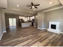 An open-concept living space featuring modern flooring, a fireplace, and a view into the kitchen at 183 Brookwood Xing, Douglasville, GA 30134