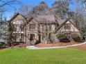 Charming two-story brick home with manicured lawn and mature trees, creating a welcoming curb appeal at 790 Denards Se Ml, Marietta, GA 30067