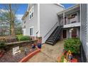 Condo with exterior staircase, gray siding, brick accents, and well-maintained landscaping at 14 Hampshire Ct, Avondale Estates, GA 30002