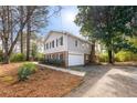 Traditional home boasts a well-maintained yard, complemented by a convenient attached garage and ample driveway space at 1105 Orchard Way, Roswell, GA 30075