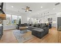 Spacious living room with a large sectional sofa, hardwood floors, and a view into the modern kitchen area at 1961 Haley Walk, Atlanta, GA 30318