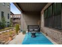 Welcoming covered patio with brick wall, brick floor, and a bright blue rug at 6460 Cortland Walk, Alpharetta, GA 30005