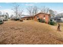 A view of a charming brick house with an expansive lawn surrounded by mature trees at 2165 Sterling Ridge Rd, Decatur, GA 30032