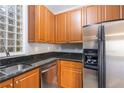 Modern kitchen boasts stainless steel appliances, wood cabinets, and granite countertops at 10 Perimeter Summit Ne Blvd # 3204, Atlanta, GA 30319