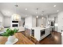 Open-concept kitchen and living room with hardwood floors and a cozy fireplace at 1872 Commons Nw Pl, Atlanta, GA 30318