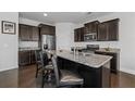 Modern kitchen island with granite countertops, stainless steel appliances, and dark wood cabinetry at 5512 Cascade Sw Run, Atlanta, GA 30336