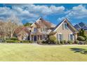 Charming two-story home with lush landscaping, a circular driveway, and classic architectural details at 955 Golf View Ct, Dacula, GA 30019