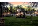 Backyard area with ambient lighting, fire pit and seating perfect for outdoor evenings at 5079 N Dogwood Hills Dr, Buford, GA 30518