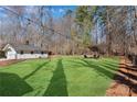 Expansive backyard with string lights, an umbrella, and a fire pit, perfect for relaxation at 5079 N Dogwood Hills Dr, Buford, GA 30518