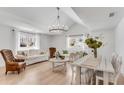 Airy living room featuring hardwood floors, ample seating, and natural light from large windows at 5079 Ne Dogwood Hills Dr, Buford, GA 30518