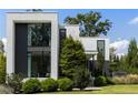 Modern home's facade with lush green landscaping against a bright blue sky at 1260 Brook Forest Ne Dr, Atlanta, GA 30324