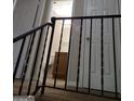 Hallway area leading to an open bathroom is lined with white doors and a black metal railing at 2627 Evans Mill Dr, Lithonia, GA 30058