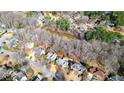 Aerial view of the property showcases a house nestled in a wooded area near a pond at 4314 Deep Springs Nw Ct, Kennesaw, GA 30144