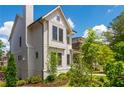 Striking two-story home with white siding, prominent chimney, and lush landscaping at 720 Tannery Cmn, Alpharetta, GA 30009