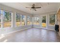 Bright sunroom with tile flooring, multiple windows, and a ceiling fan, perfect for enjoying the outdoors indoors at 160 Alpine Dr, Roswell, GA 30075