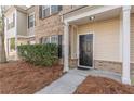 Inviting front entrance featuring a dark-stained front door and manicured landscaping at 1732 Broad River Rd, Atlanta, GA 30349