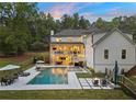 Resort-style backyard featuring a large pool, integrated spa, ample lounge seating, and outdoor dining area at 650 Jones Rd, Roswell, GA 30075