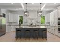 Bright kitchen with a large island, stainless steel appliances, granite countertops, and modern pendant lighting at 650 Jones Rd, Roswell, GA 30075