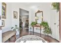 Inviting foyer with hardwood floors, decorated with a ornate mirror, a bench and greenery at 2817 Middlecreek Way # 1703, Cumming, GA 30041