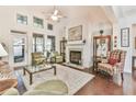 Bright living room featuring hardwood floors, a fireplace, and large windows, creating a cozy and inviting atmosphere at 2817 Middlecreek Way # 1703, Cumming, GA 30041