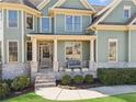 Inviting front porch with brick accents, outdoor seating, and well-manicured landscaping at 2952 Perimeter Cir, Buford, GA 30519