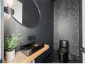 Stylish powder room with a black geometric tiled accent wall, modern fixtures, and sleek design at 198 Johnson Ferry Nw Rd, Atlanta, GA 30328
