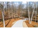 View of the driveway leading to the property's gate and surrounding landscape at 8710 Little Mill Rd, Cumming, GA 30041