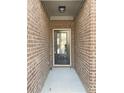 Exterior view of the front door surrounded by brick on a covered portion of the front porch at 2677 Pearl Ridge Trce, Buford, GA 30519