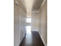 Hallway with dark hardwood floors, leading into a room filled with natural light at 2677 Pearl Ridge Trce, Buford, GA 30519