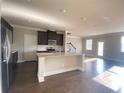 Open kitchen with a granite island, stainless steel appliances and dark wood floors at 2677 Pearl Ridge Trce, Buford, GA 30519