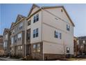 Three-story end unit townhome features brick and tan siding, multiple windows, and mature landscaping at 504 Sonata Walk, Marietta, GA 30067