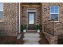 Charming front entrance with brick, planters, welcome mat and a glass door at 504 Sonata Walk, Marietta, GA 30067