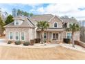 Charming two-story brick home featuring a well-manicured lawn and beautiful landscaping, including palm trees at 1227 Castle Point Sw Ct, Conyers, GA 30094