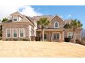 Elegant two-story brick home with a well-kept lawn, mature landscaping, and a welcoming covered entryway at 1227 Castle Point Sw Ct, Conyers, GA 30094