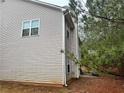 An exterior side view of the home shows neutral siding, a basketball net, and limited backyard at 114 Crescent Woode Way, Dallas, GA 30157