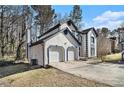 View of the garage and driveway, featuring stucco siding, and blue trim at 624 Longbow Ct, Stone Mountain, GA 30087