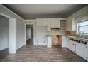 Kitchen with granite countertops, white cabinets, and laminate flooring at 3500 Quail Hollow Trl, Snellville, GA 30039