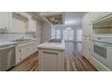 Bright kitchen with an island cooktop, stainless appliances, and a view of the breakfast area at 4570 Thicket Trl, Snellville, GA 30039