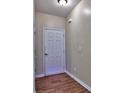 Foyer with wood-look floors, white door, neutral walls, and a ceiling light fixture providing a warm welcome at 2357 Barrett Cottage Pl, Marietta, GA 30066